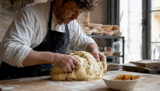 Des mains pétrissent délicatement la pâte à panettone au levain.