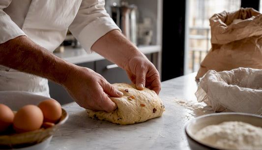 Des mains façonnent délicatement une pâte de panettone au levain.