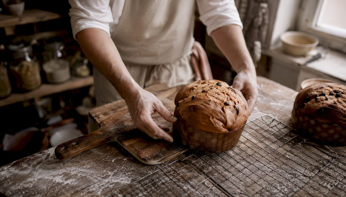 On voit des mains démouler un panettone tout juste sorti du four.