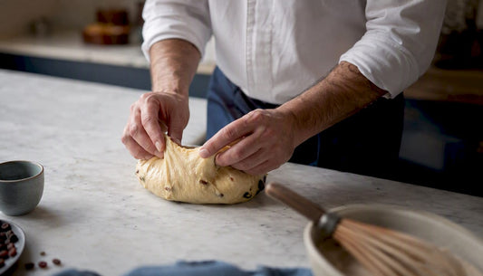 Des mains façonnent la pâte à panettone en réalisant le geste traditionnel de la pirlatura, une technique essentielle pour obtenir sa texture si aérienne.