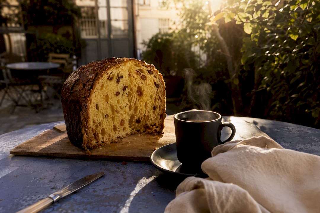 Panettone coupé en deux sur la table avec une tasse d'expresso