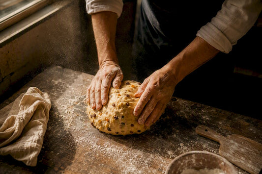 Mains en train de plier la pâte à panettone au levain
