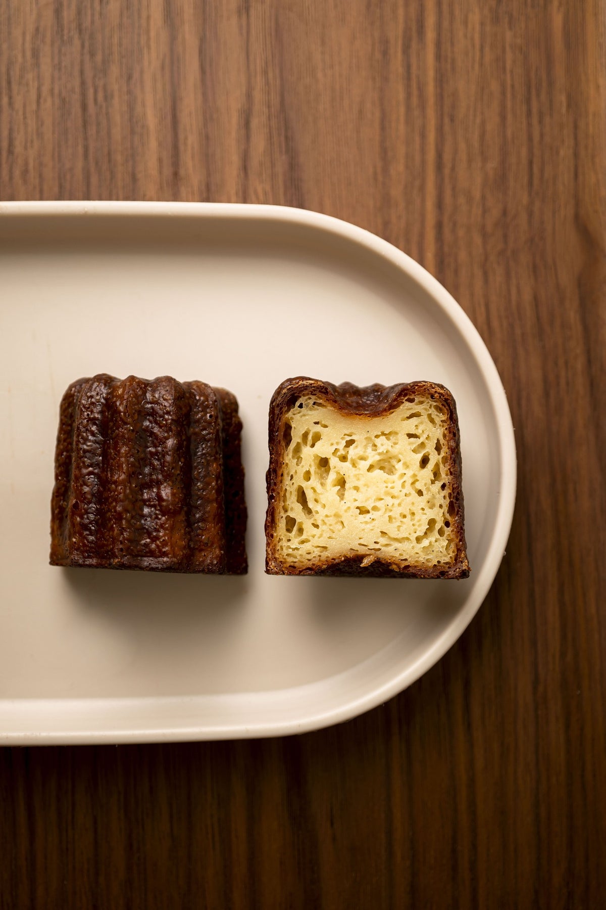Cannelé tranché révélant l'intérieur alvéolé et fondant au rhum et vanille de Bordeaux