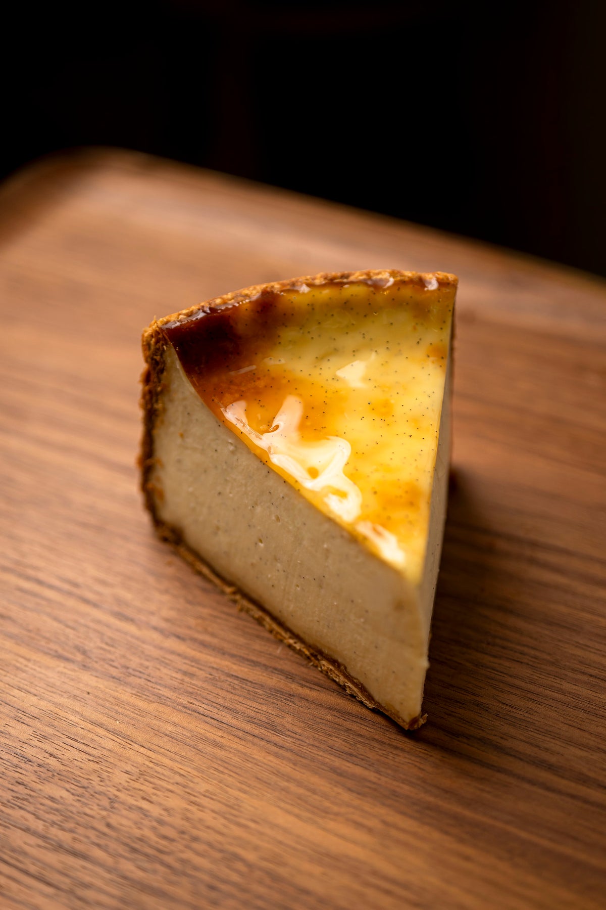 Tranche de flan parisien vanille révélant une crème dense et dorée sur base feuilletée
