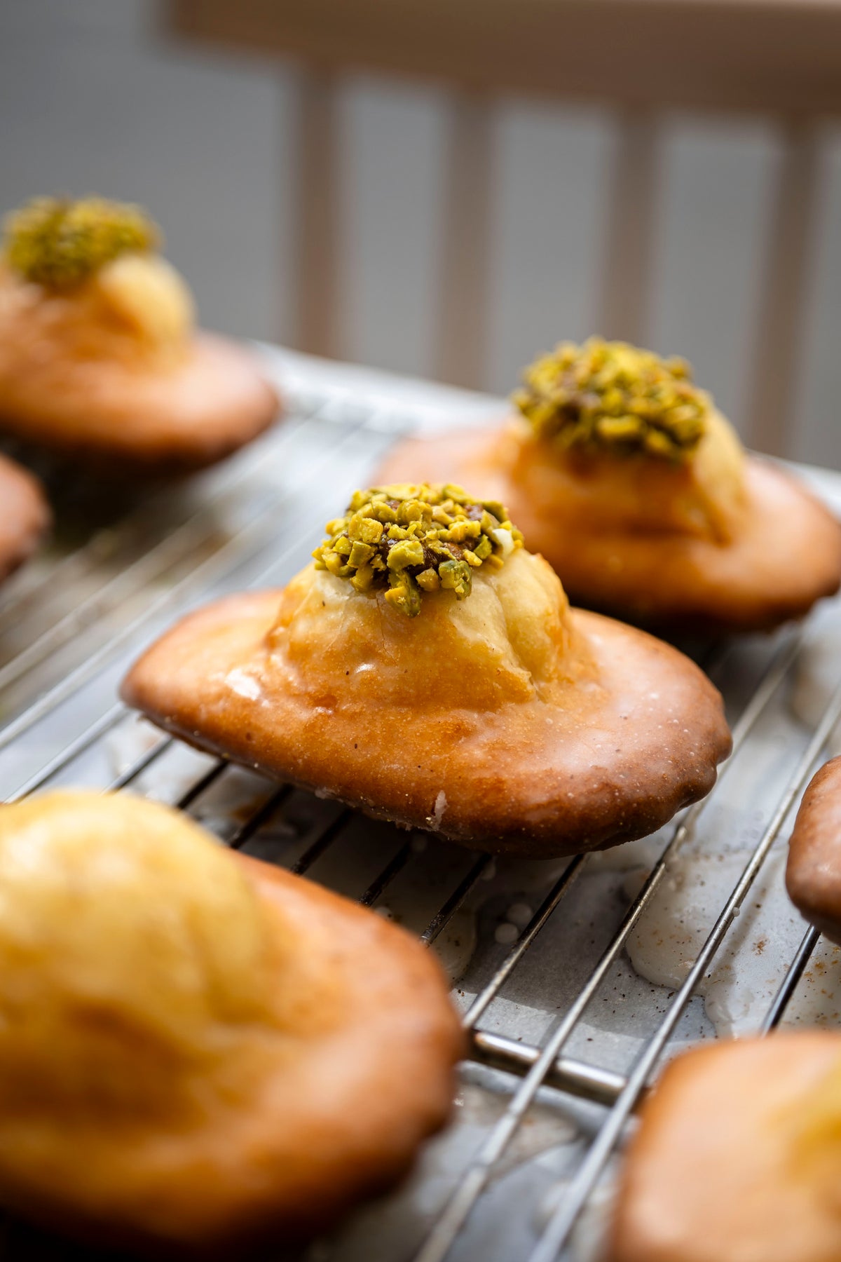 Madeleine praline pistache tranchée révélant une mie dorée aux éclats de pistache verte