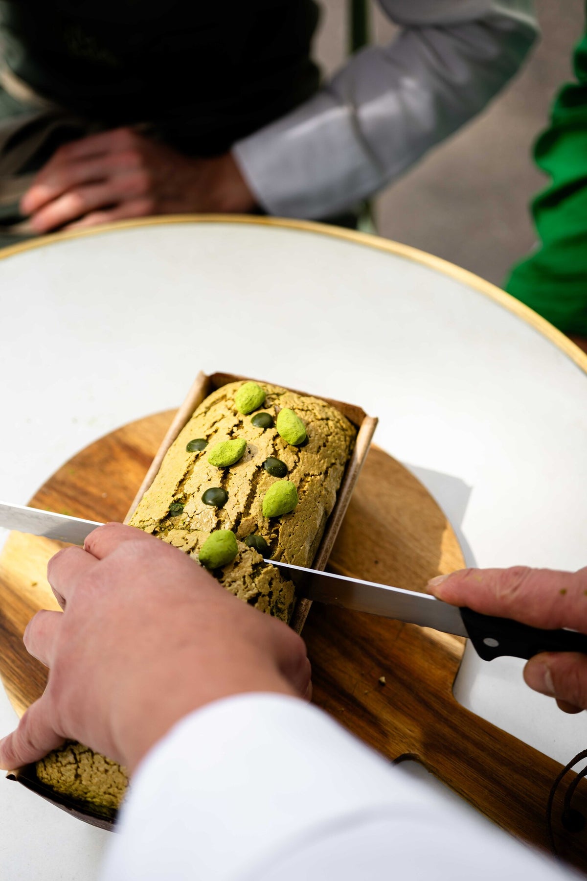 Brioche matcha Christophe Louie entière décorée de fraises confites sur ardoise noire