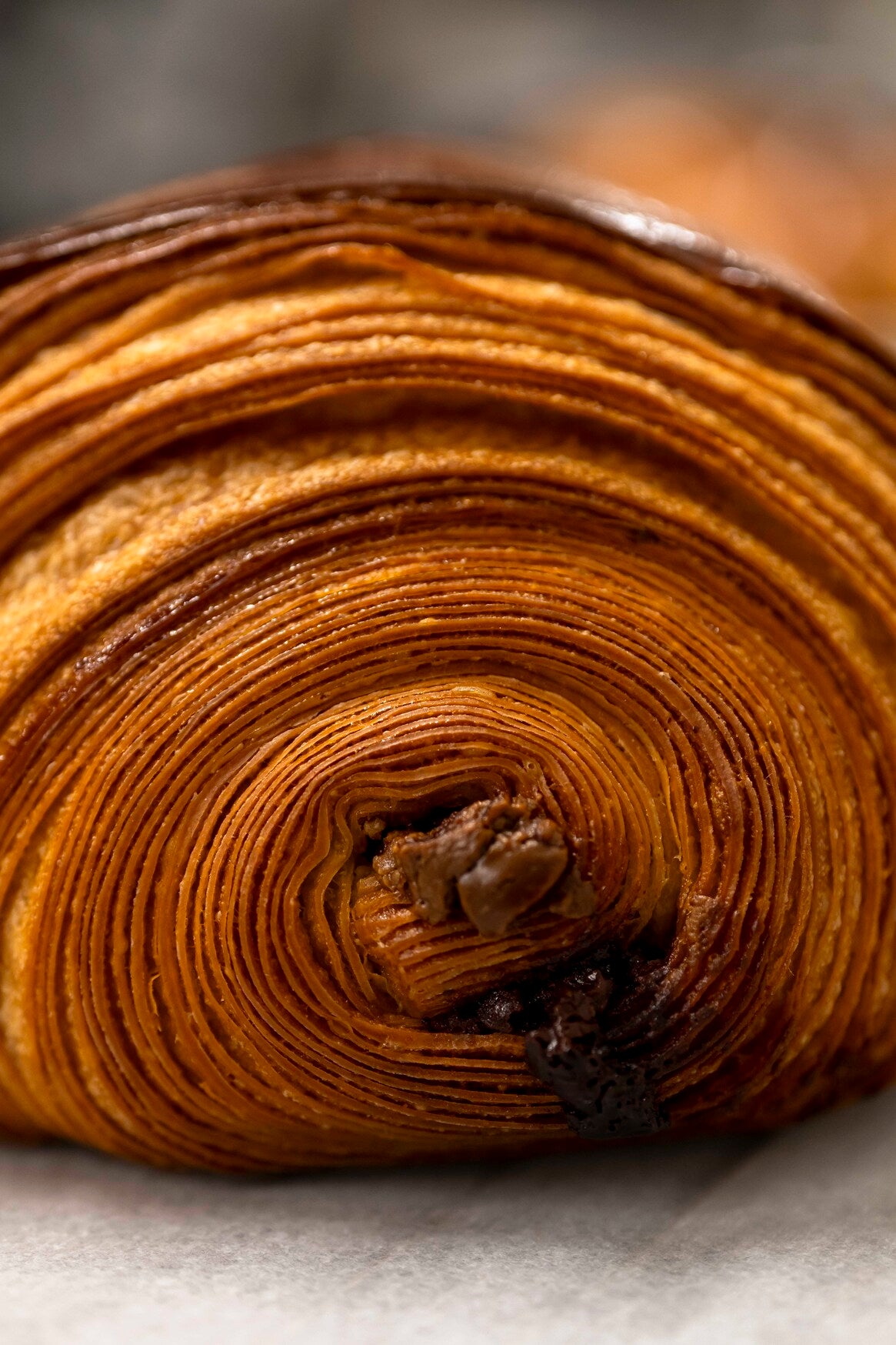 Intérieur feuilleté du pain au chocolat Christophe Louie révélant les barres de chocolat fondant