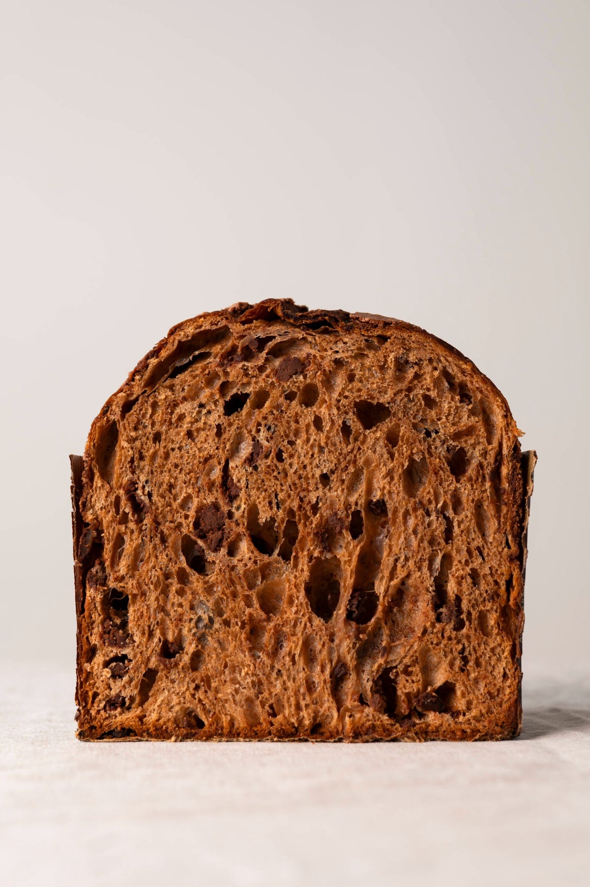 Panettone gianduja tranché révélant une mie aérée aux noisettes et chocolat au lait fondant