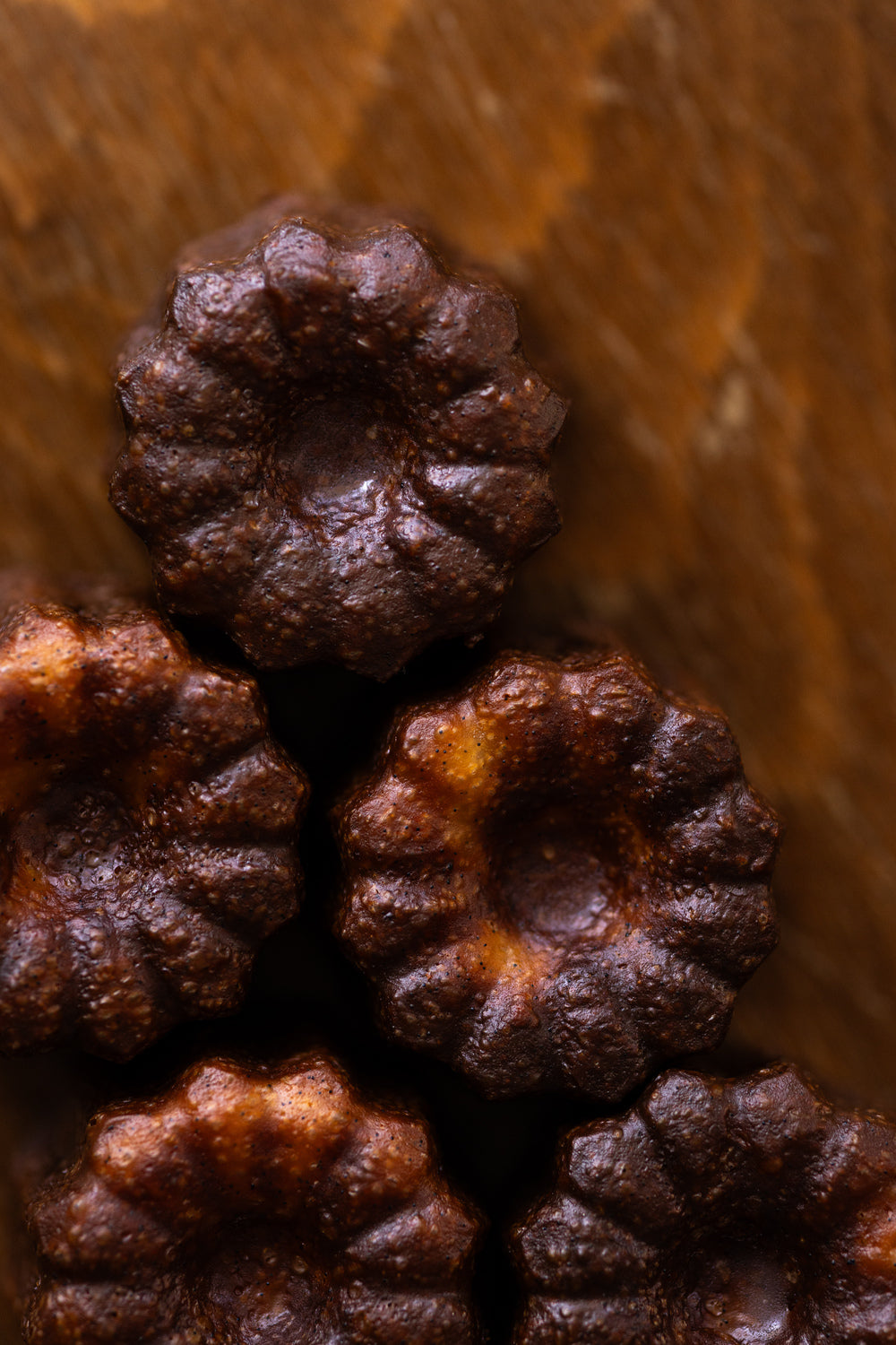 Gros plan sur la croûte laquée et caramélisée du cannelé artisanal Christophe Louie
