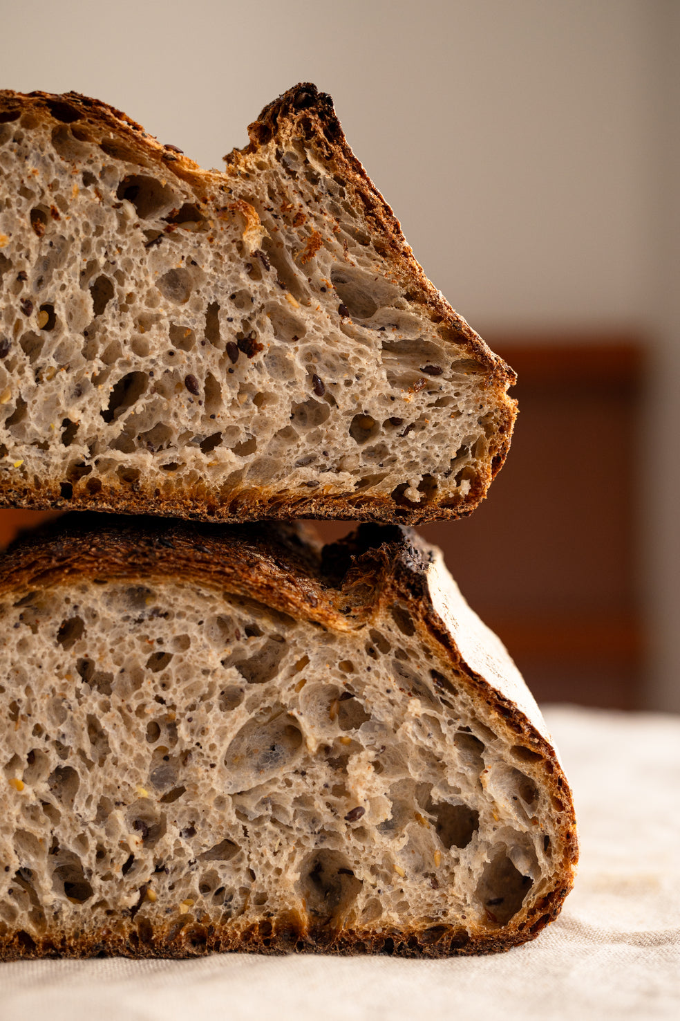 Tranche de pain de campagne aux graines révélant une mie aérée aux alvéoles irrégulières